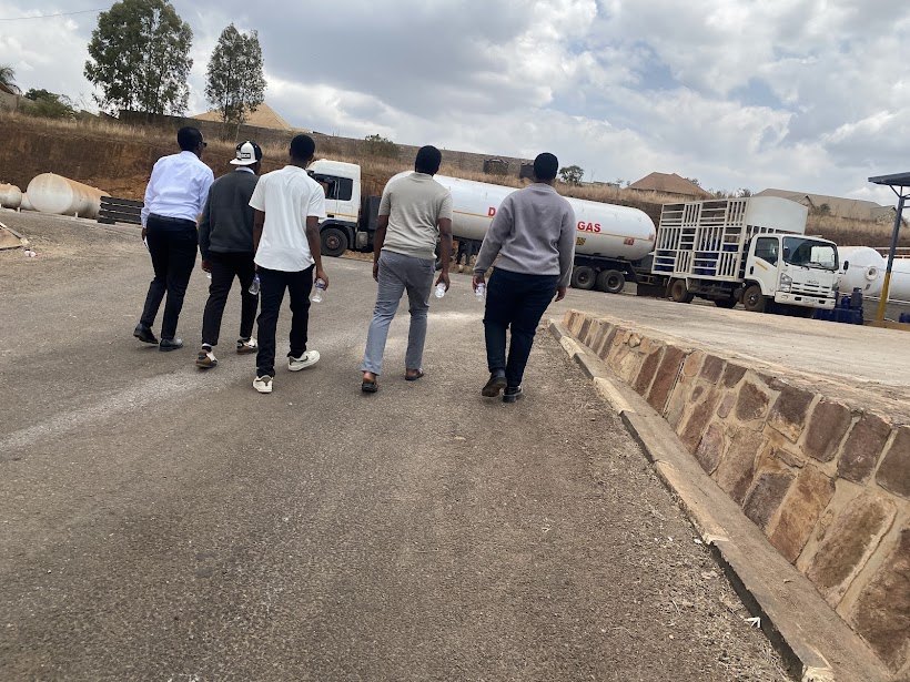 The Entelon team walking through the Hoyo site among gas tankers